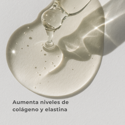 Glass dropper with clear liquid on a light gray background, text 'Aumenta niveles de colágeno y elastina' displayed.