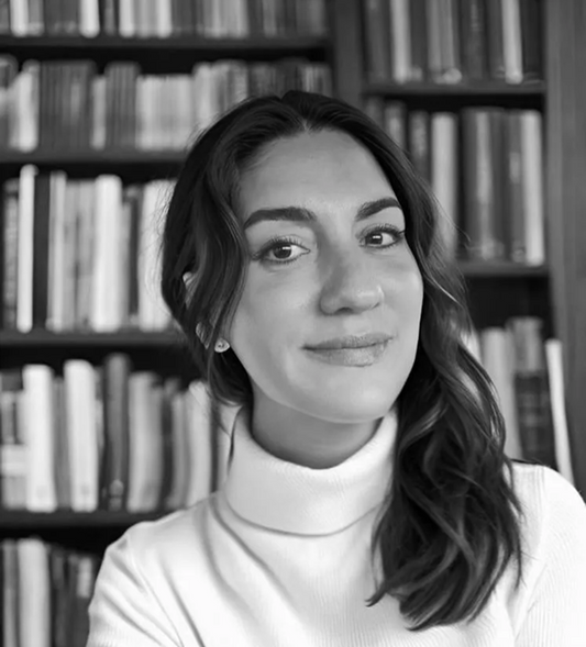 Black and white portrait of a woman in front of a bookshelf